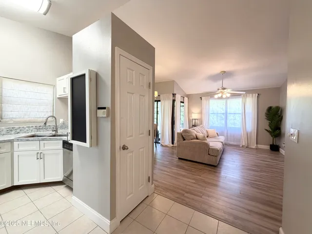 a living room with stainless steel appliances kitchen island granite countertop furniture and a wooden floor