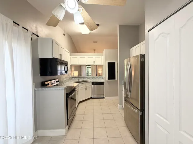a kitchen with stainless steel appliances a refrigerator sink and stove
