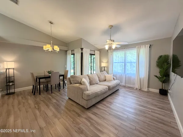 a living room with furniture and a chandelier