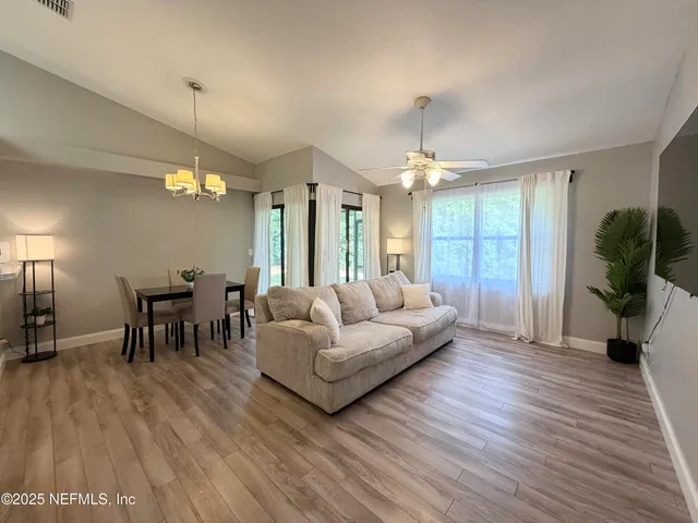 a living room with furniture and a chandelier