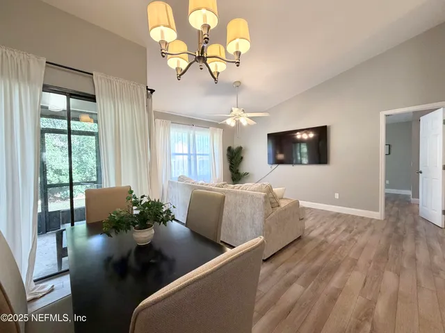 a living room with furniture chandelier and a flat screen tv