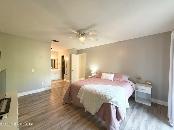 a bedroom with a bed and wooden floor