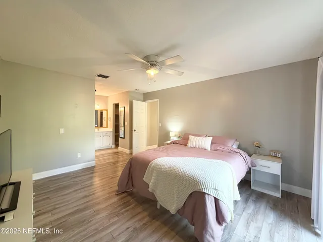 a bedroom with a bed and wooden floor