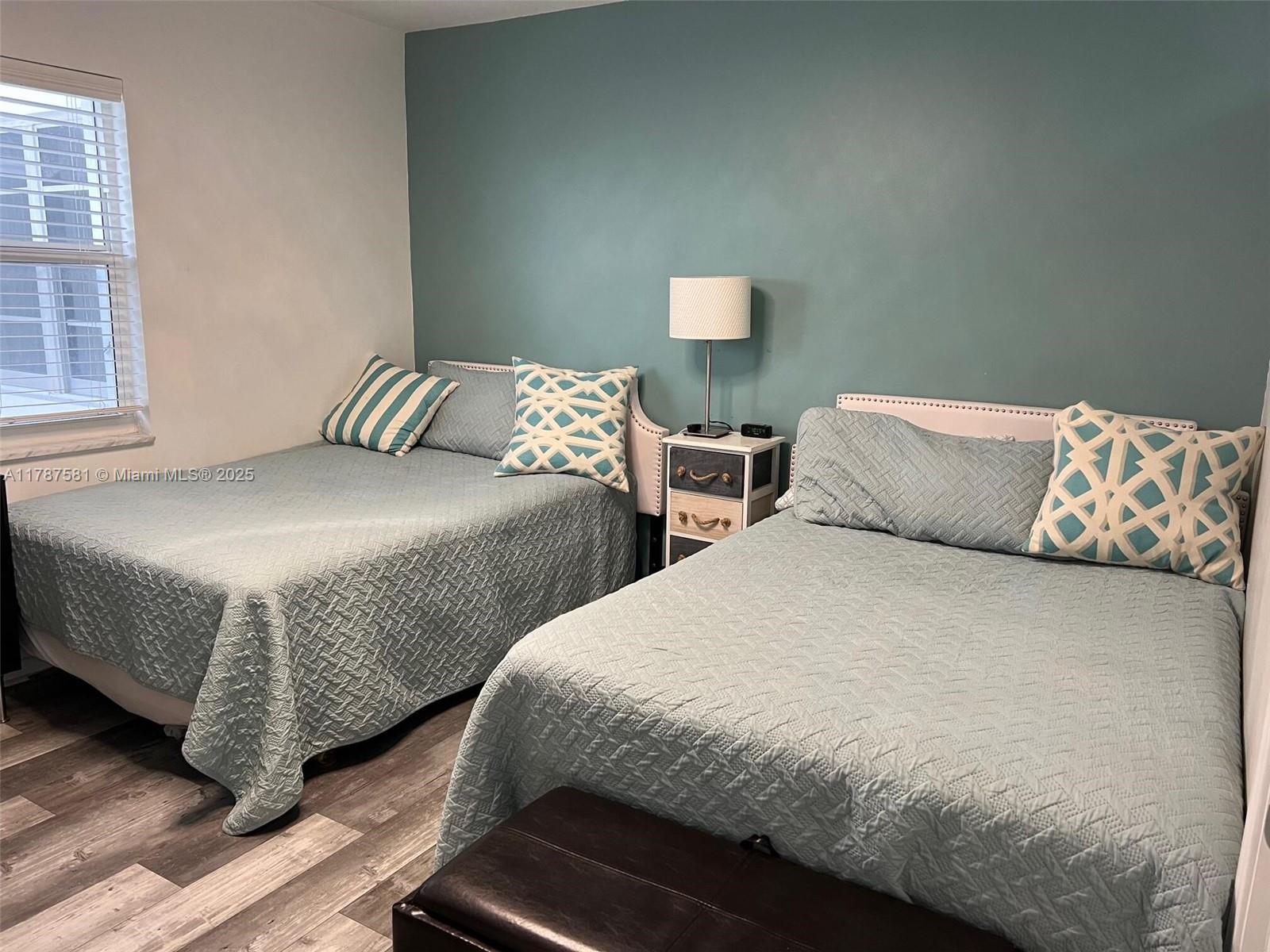 1500 South Ocean Boulevard, Unit 907 Pompano Beach, FL 33062 - Photo 13 of 14 a bedroom with two beds and wooden floor