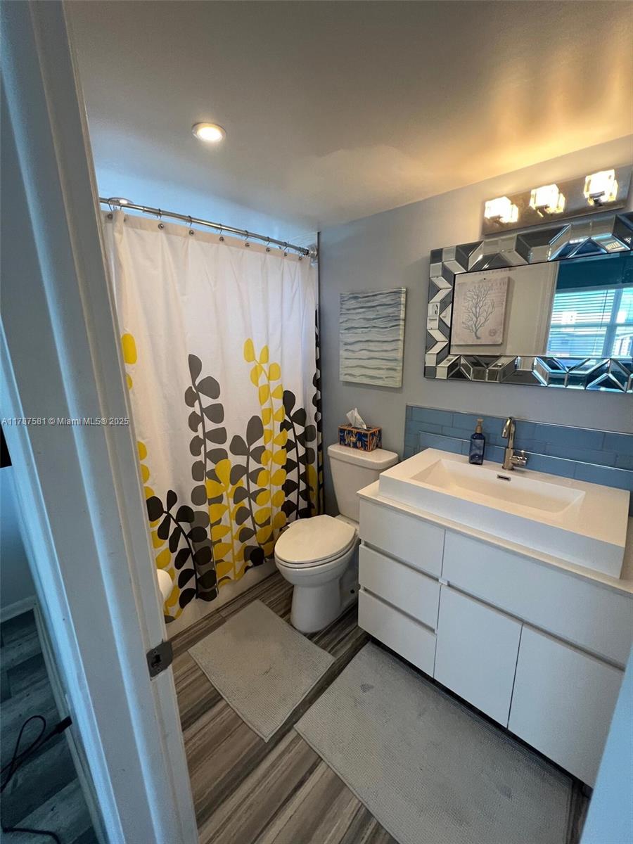 1500 South Ocean Boulevard, Unit 907 Pompano Beach, FL 33062 - Photo 14 of 14 a bathroom with a toilet sink and mirror