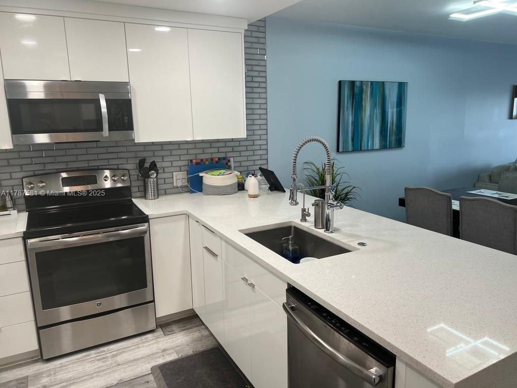 1500 South Ocean Boulevard, Unit 907 Pompano Beach, FL 33062 - Photo 10 of 14 a kitchen with stainless steel appliances a sink a stove and cabinets