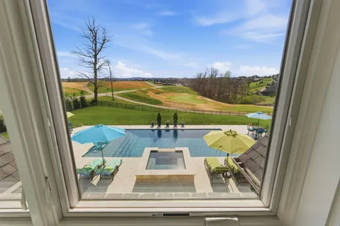 a view of house with swimming pool and patio