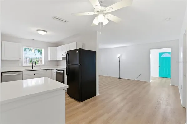 a kitchen with granite countertop a refrigerator and a sink