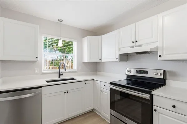 a kitchen with appliances cabinets and a window
