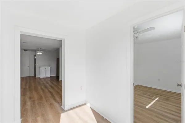 a view of a hallway with wooden floor and closet