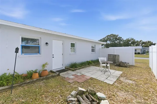 a backyard of a house with table and chairs