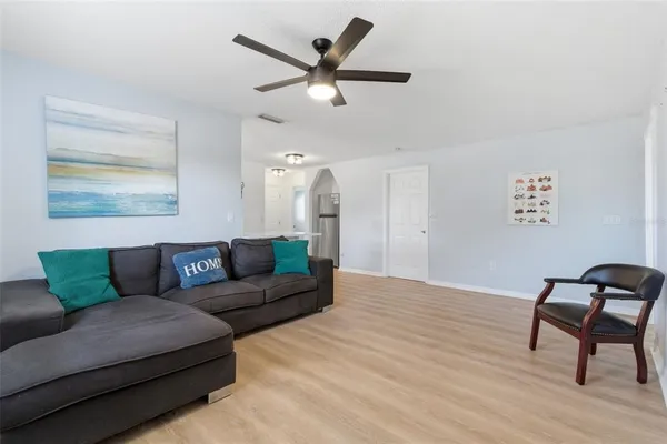 a living room with furniture and a wooden floor