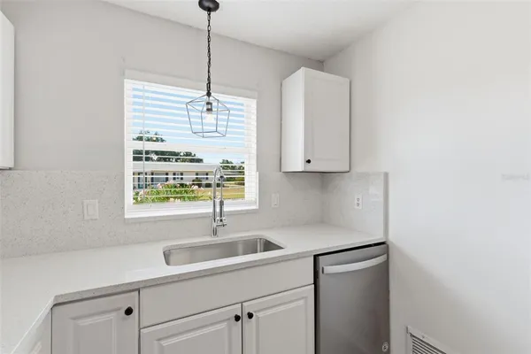 a kitchen with a sink cabinets and window
