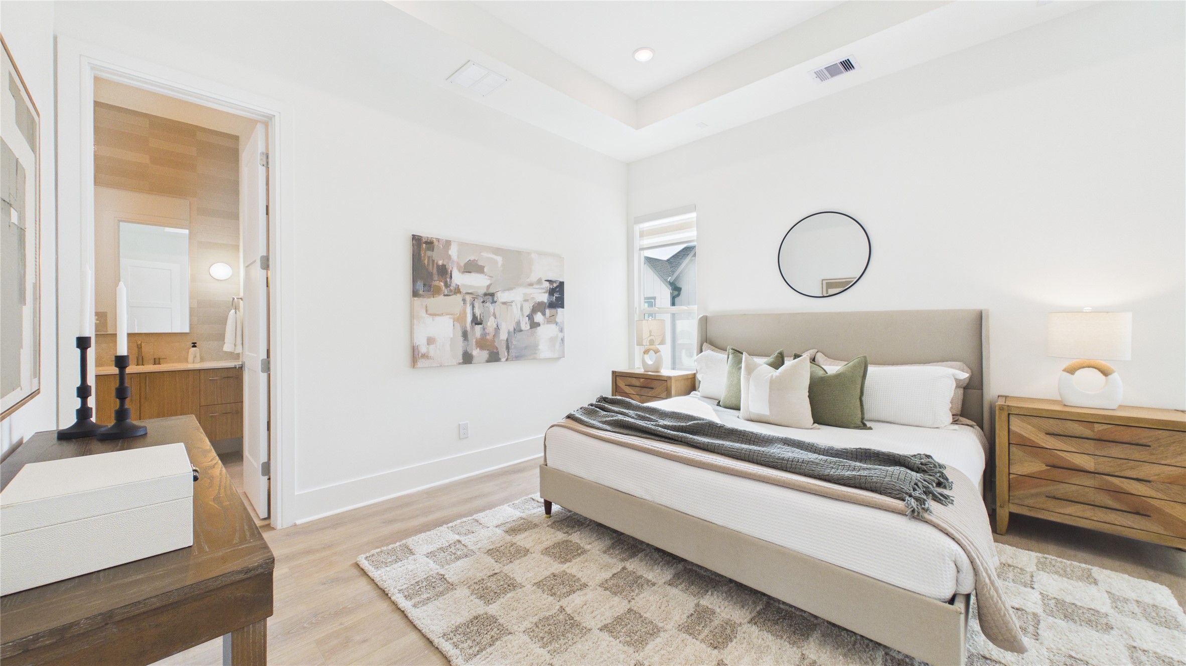 602 Skyland Terrace Way Houston, TX 77009 - Photo 27 of 40 This bright bedroom features a modern design with neutral tones, a comfortable bed, stylish nightstands, and a cozy rug. It includes an attached bathroom and has ample natural light.