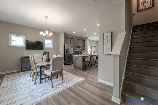 a living room with furniture a dining table wooden floor and a fireplace