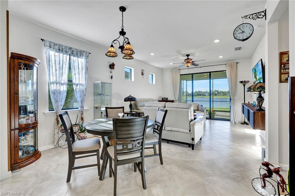 2171 Yellowfin Circle Naples, FL 34114 - Photo 12 of 38 a living room with furniture a floor to ceiling window and a flat screen tv