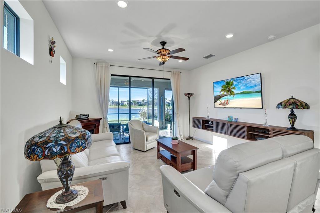2171 Yellowfin Circle Naples, FL 34114 - Photo 13 of 38 a living room with furniture a chandelier and a window