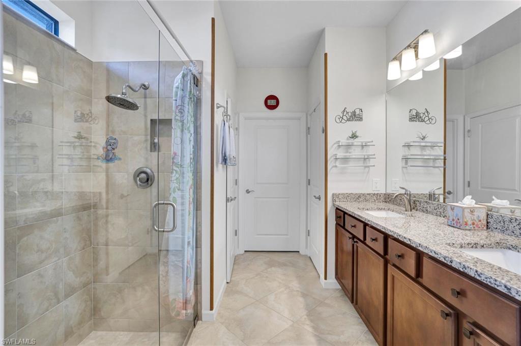 2171 Yellowfin Circle Naples, FL 34114 - Photo 14 of 38 a bathroom with a granite countertop shower sink and mirror