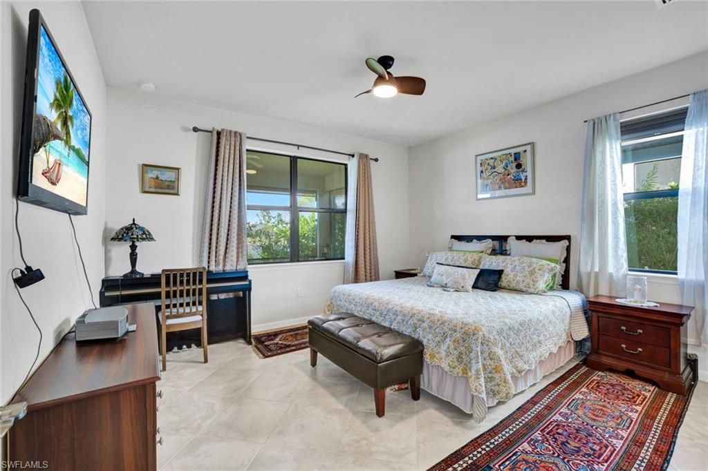 2171 Yellowfin Circle Naples, FL 34114 - Photo 16 of 38 a bedroom with a bed and a dresser next to a window