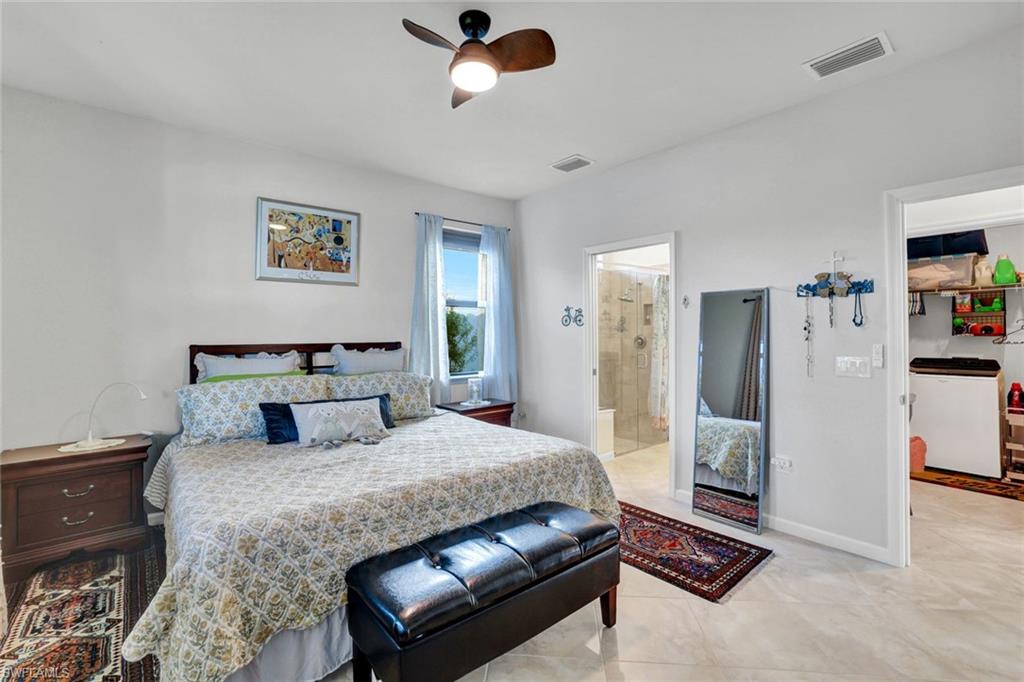 2171 Yellowfin Circle Naples, FL 34114 - Photo 17 of 38 a bedroom with a large bed and a chandelier
