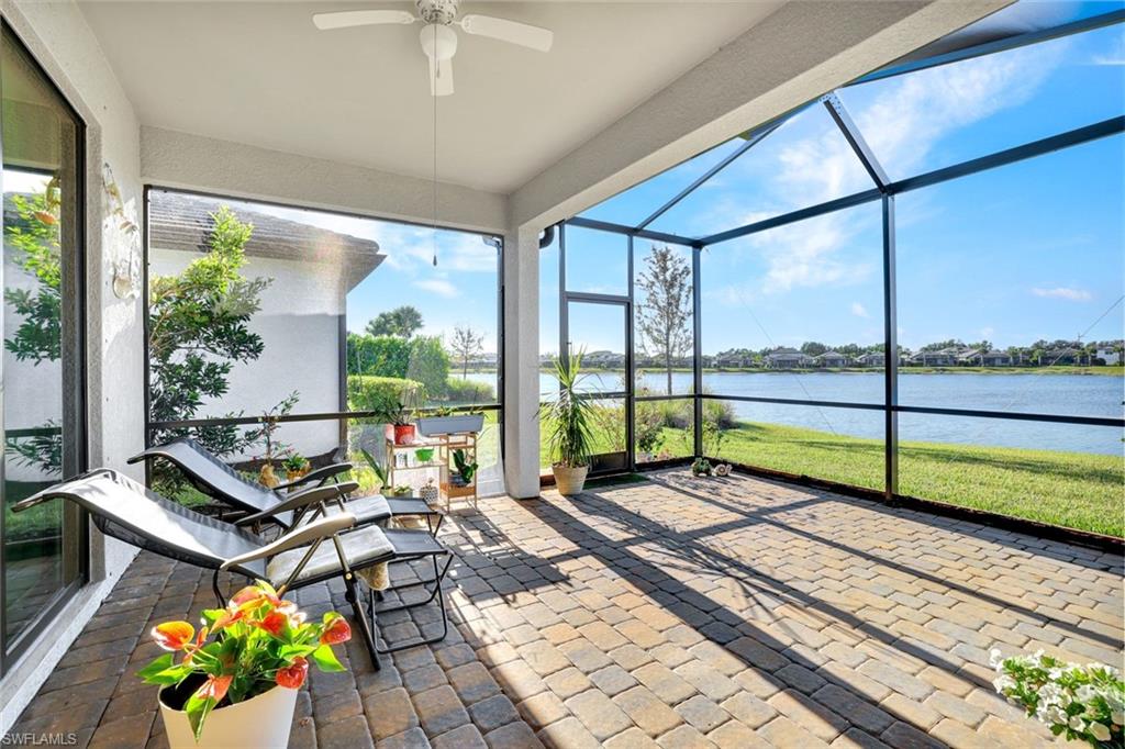 2171 Yellowfin Circle Naples, FL 34114 - Photo 2 of 38 a living room with a floor to ceiling window and a table