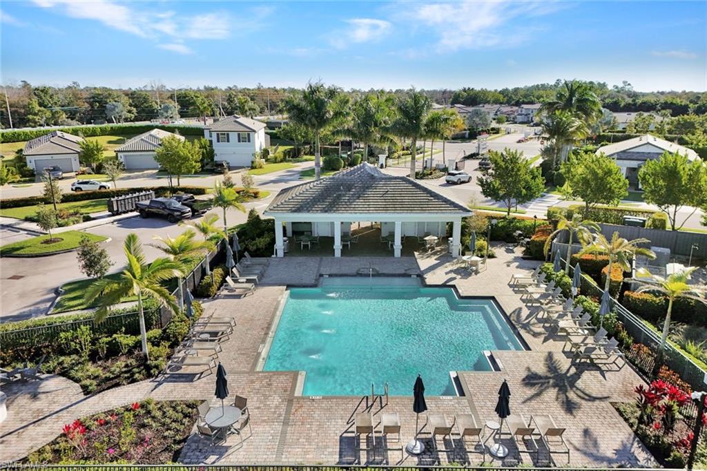2171 Yellowfin Circle Naples, FL 34114 - Photo 29 of 38 a view of a garden with lawn chairs under an umbrella