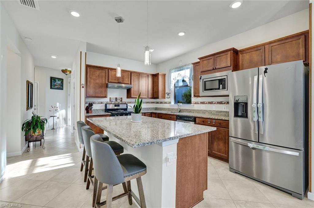 2171 Yellowfin Circle Naples, FL 34114 - Photo 7 of 38 a kitchen with stainless steel appliances a refrigerator and a stove top oven