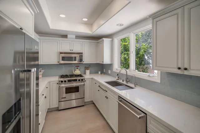 a kitchen with a sink stove top oven and refrigerator