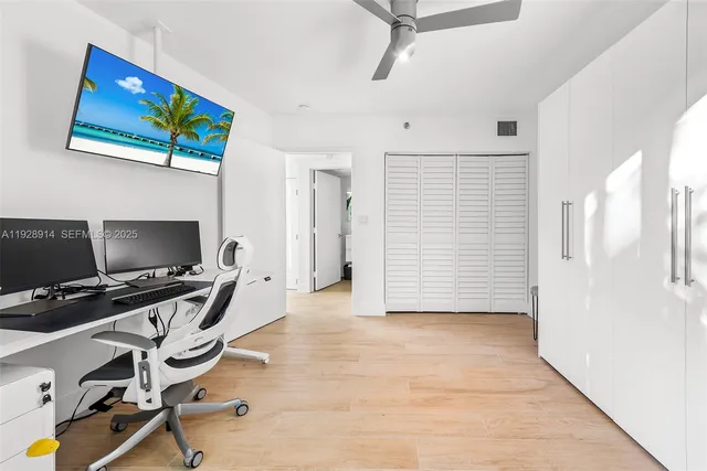 a view of a workspace with furniture and a ceiling fan