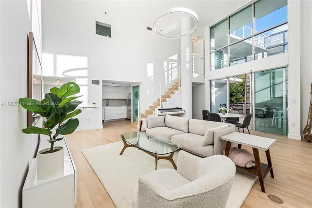 a living room with furniture a large window and a fireplace