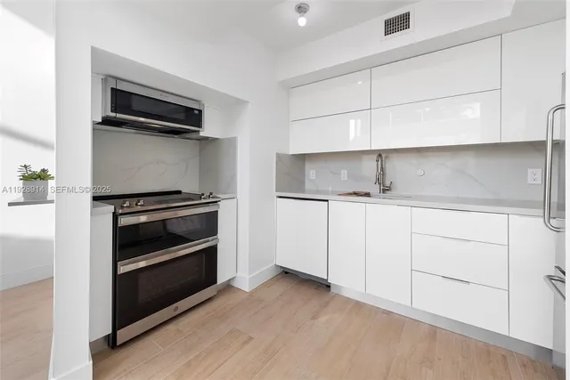 a kitchen with a sink appliances and cabinets
