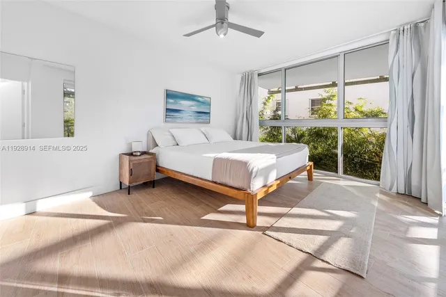 a bedroom with a bed and large window with balcony view