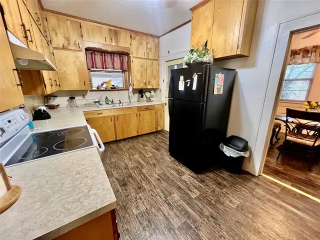 a kitchen with stainless steel appliances granite countertop a refrigerator a stove and a sink