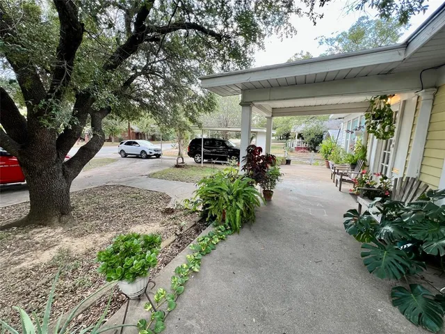 a couple of cars parked in front of yellow house