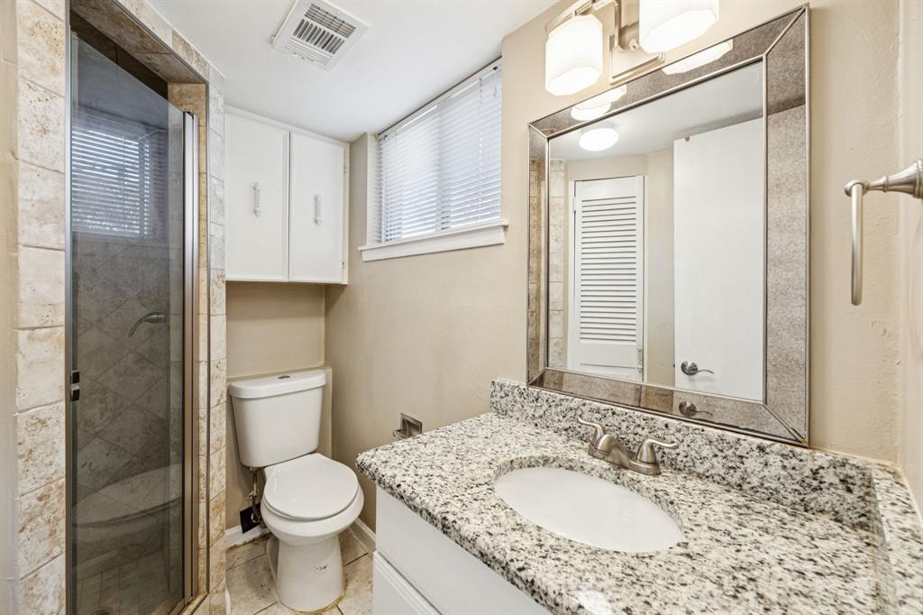 2017 Durham Street Irving, TX 75062 - Photo 13 of 26 a bathroom with a granite countertop sink toilet and shower