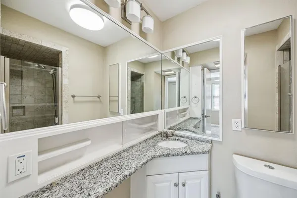 a bathroom with a granite countertop sink mirror and vanity