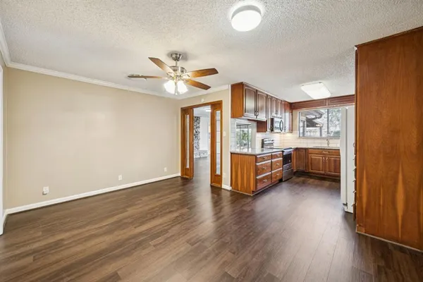 a living room with stainless steel appliances furniture and a kitchen view