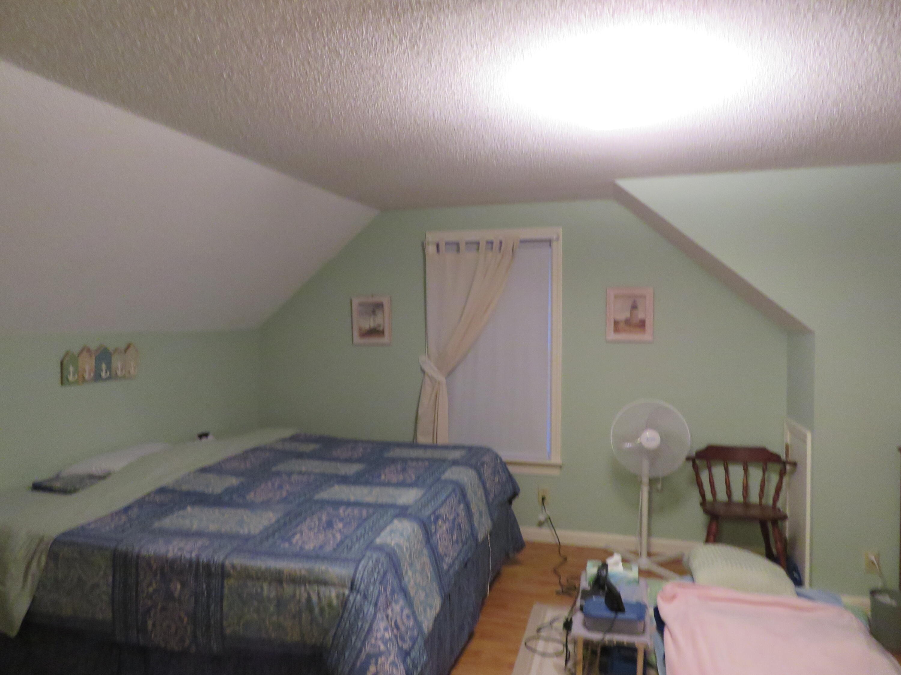 65 Clayton Road Eastham, MA 02642 - Photo 6 of 12 a bedroom with a bed and a chair