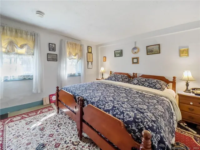 a bedroom with bed and wooden floor