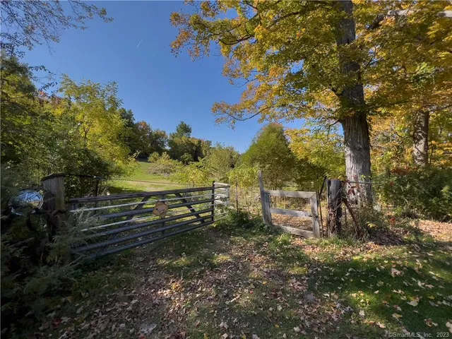 a view of a yard with wooden fence