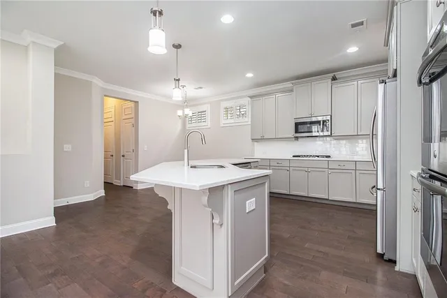 a kitchen with stainless steel appliances sink stove refrigerator and cabinets
