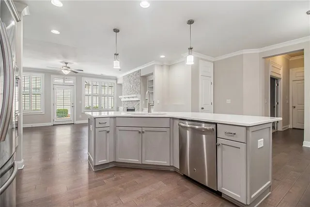 a kitchen that has a lot of white cabinets and stainless steel appliances