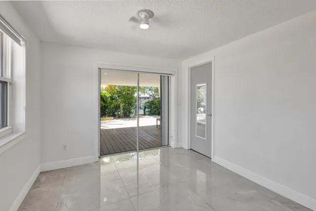 an empty room with glass door and shower