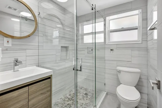 a bathroom with a toilet a sink and mirror