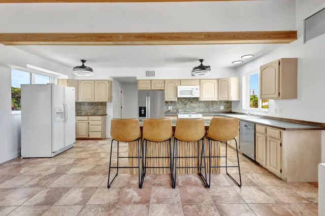 a kitchen with stainless steel appliances granite countertop a sink and a refrigerator