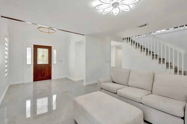 a living room with furniture and a chandelier