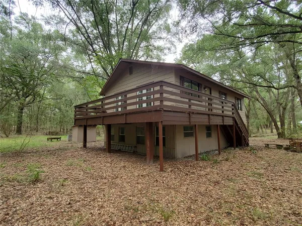 a view of a house with a yard and large tree