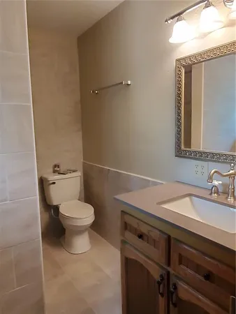 a bathroom with a toilet a sink and mirror