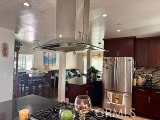 a kitchen with stainless steel appliances granite countertop a refrigerator and a stove