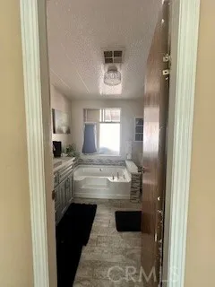 a bathroom with a granite countertop sink a mirror and a bathtub